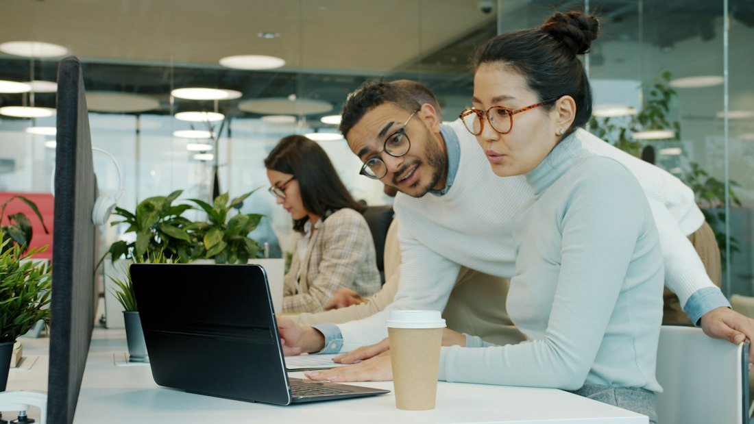 Team collaborating around a laptop
